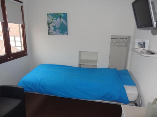 a room with a bed with a blue blanket at 't Reijmerhöfke in Reijmerstok