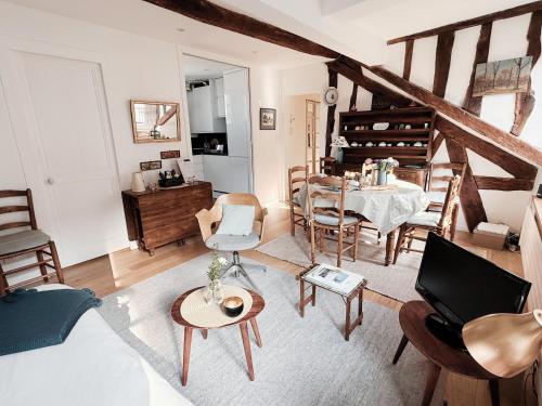 un salon avec une table et des chaises dans l'établissement Le Mansart classé 3 étoiles Charme ancien et Havre de paix, à Versailles