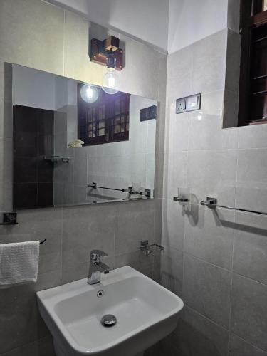 a bathroom with a white sink and a mirror at Villa Vinstar in Katukurunda-Kalutara