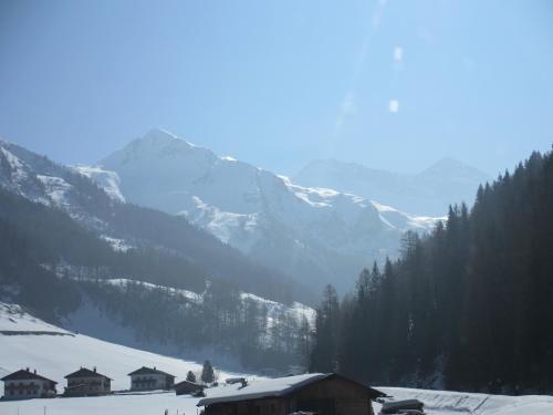 a snow covered mountain range with houses in the foreground at Ferienwohnung Plattner in Schmirn