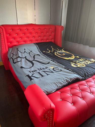 a red couch with a blanket on top of it at W District Guesthouse in Bangkok