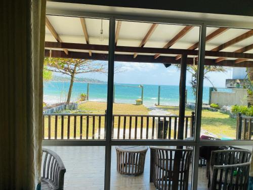 a room with a view of the ocean from a porch at Sea Bay Point in Mawella