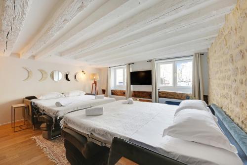 - une chambre avec 3 lits et une télévision à écran plat dans l'établissement MyKeypers - Deluxe Flat 6P - St Germain des Pres Café de FLORE, à Paris