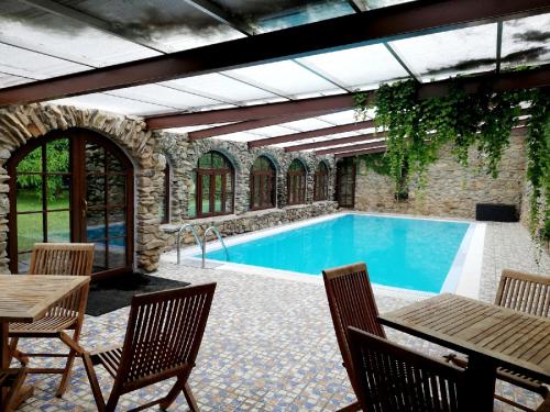 een zwembad in een patio met stoelen en een tafel bij Statek u Badyho in Dolní Třebonín