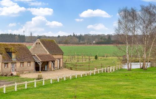 an old house in a field with a fence at Lovely Home In Les Baux De Breteuil in Les Baux-de-Breteuil