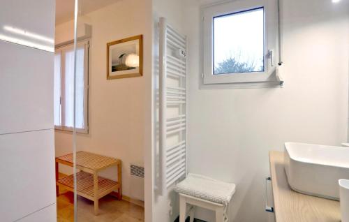 a white bathroom with a sink and a window at Cozy Home In Quettehou With Wifi in Quettehou