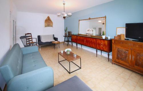 un salon avec un canapé bleu et une télévision dans l'établissement Awesome Apartment In Carpentras, à Carpentras