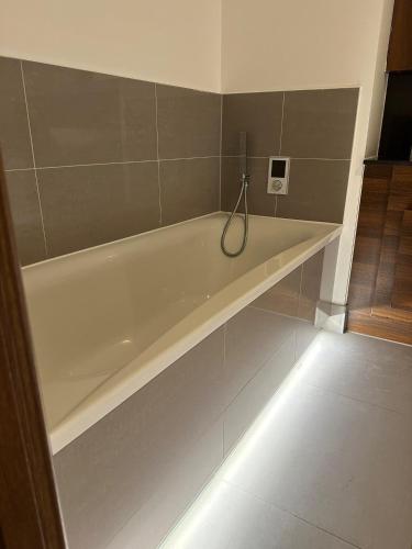 a white bath tub in a bathroom with a light at Charming Dartford Apartment Retreat in Dartford