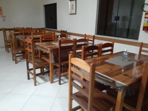 a dining room with wooden tables and chairs at Pousada São Nicolau in Cachoeira Paulista