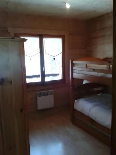 une chambre avec un lit superposé et une fenêtre dans l'établissement Chalet Le Flocon, à Sixt-Fer-à-Cheval