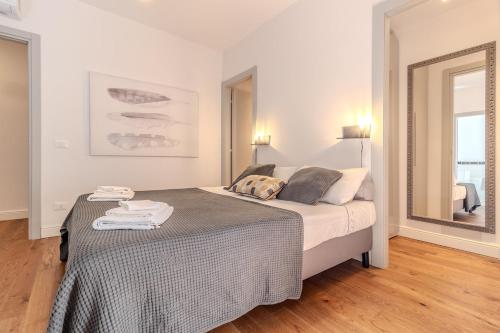 a bedroom with a large bed in a room with a mirror at Blue Como Luxury Apt#3 in Como