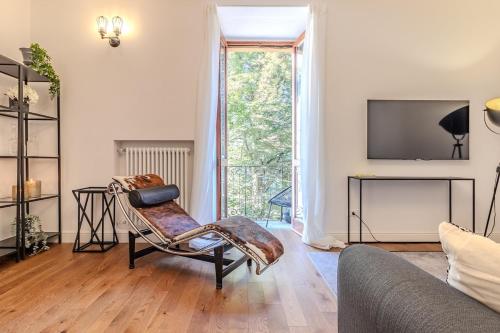 a living room with a chair and a tv at Blue Como Luxury Apt#3 in Como