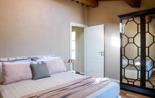 a bedroom with a bed with pink and grey pillows at Awesome Home In Massa E Cozzile in Massa e Cozzile