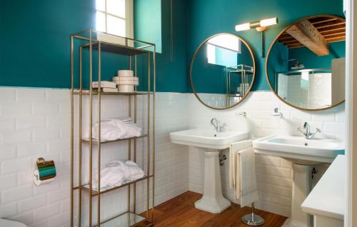 a bathroom with two sinks and two mirrors at Awesome Home In Massa E Cozzile in Massa e Cozzile