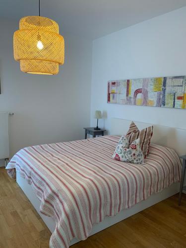 a bedroom with a bed with a striped blanket at Casa Cinzia Rosa in Eckernförde