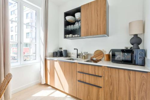 une cuisine avec un évier et un micro-ondes dans l'établissement Superb 1BR Flat 10 min from Bon Marché Rive Gauche, à Paris