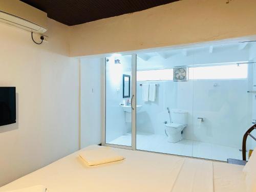 a bathroom with a toilet and a large glass window at Sea Bay Point in Mawella