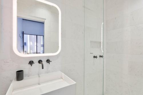 une salle de bain blanche avec un lavabo et un miroir dans l'établissement Superb 1BR Flat 10 min from Bon Marché Rive Gauche, à Paris