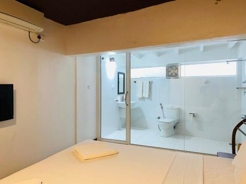 a bathroom with a toilet and a glass window at Sea Bay Point in Mawella