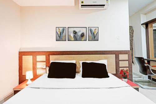 a bedroom with a large white bed with two pillows at Hotel O Anantapur in Anantapur