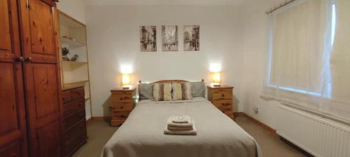una camera da letto con un letto con due comodini e due lampade di Rustic Harmony - Edinburgh Airport near, 8mi a Rosyth