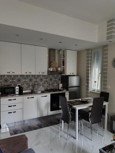 a kitchen with white cabinets and a table and chairs at Zahira2 in Rapallo