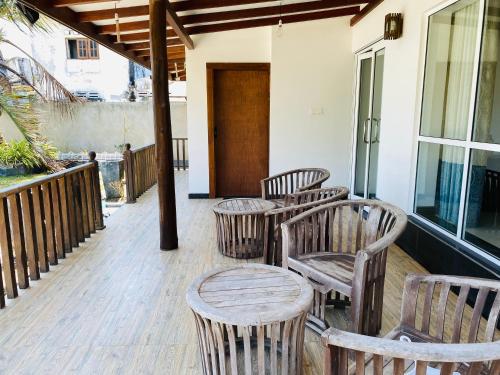 a porch with four wooden chairs and a table at Sea Bay Point in Mawella