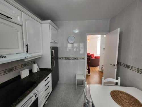 a kitchen with white cabinets and a sink at Laxe Piso Sol - Wifi y Netflix in Laxe