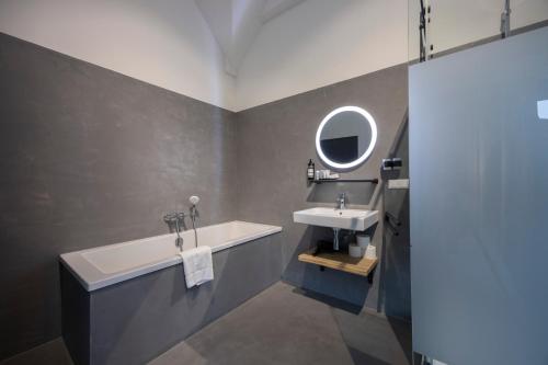 a bathroom with a sink and a tub and a mirror at "Het Wapen Van Willemstad" in Willemstad