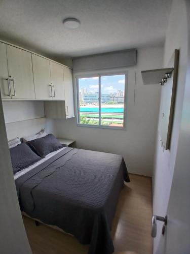 a bedroom with a bed and a large window at Sabiá -Apartamento próximo ao Allianz Park e Metrô Barra Funda in Sao Paulo