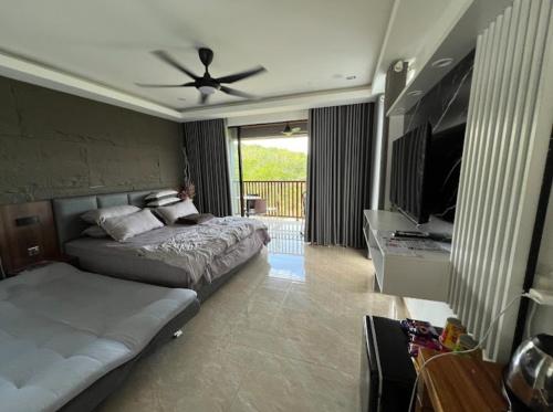 a bedroom with a bed and a flat screen tv at CBHResort Agrofarm in Kampong Benchah Tualang