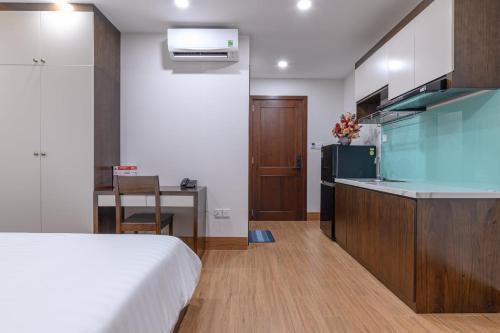 a bedroom with a bed and a kitchen with a desk at LaBi Hotel n Apartment Danang in Da Nang