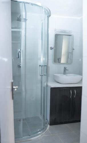 a bathroom with a glass shower and a sink at The Serenity Space in Pātan