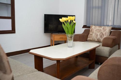 a vase of flowers on a coffee table in a living room at The Serenity Space in Pātan