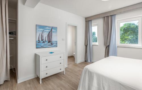 a white bedroom with a bed and two windows at Rab Barbat Villas 4 stars 300 sea in Barbat na Rabu