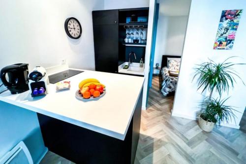 une cuisine avec un bol de fruits sur un comptoir dans l'établissement Joli studio cœur de ville, à Avignon