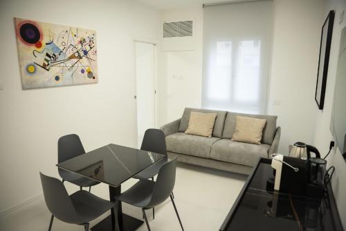 a living room with a table and chairs and a couch at Emme Suite in Cisterna di Latina