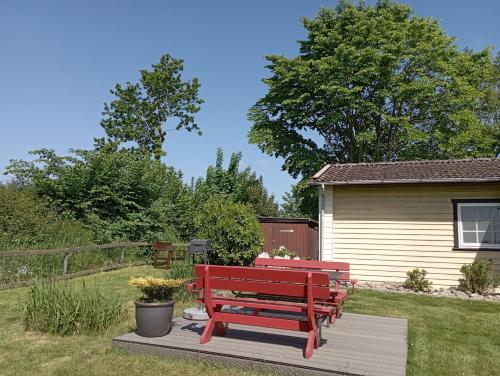 a red bench sitting on a deck in a yard at Ferienhaus "Op'n Barg" in Holzbunge