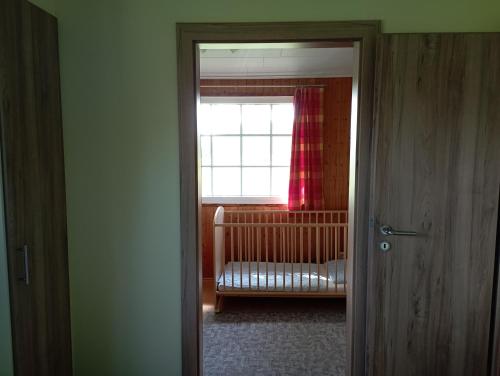 a room with a crib and a window at Ferienhaus "Op'n Barg" in Holzbunge