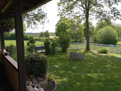 a view of a yard with a bench in the grass at Ferienhaus "Op'n Barg" in Holzbunge