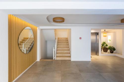 a hallway with a staircase and a mirror on the wall at Hotel Brisa Marina in S'Illot