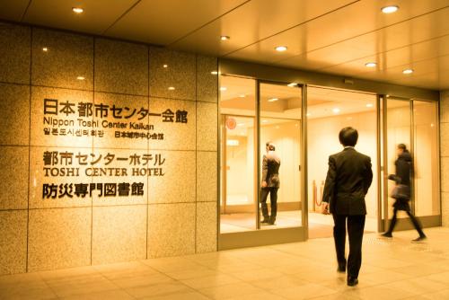 a man walking in front of a store at Toshi Center Hotel in Tokyo
