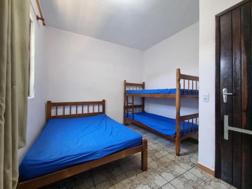 una camera con 2 letti a castello e una porta di Ohana Casa 2 Boraceia a Bertioga