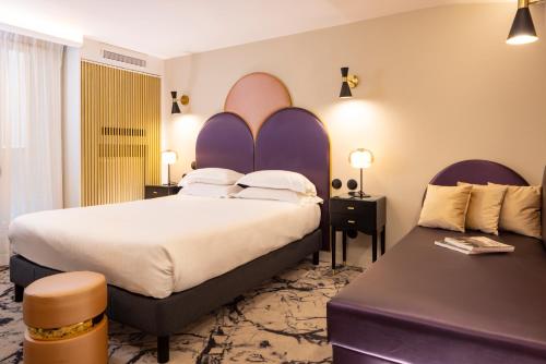 a hotel room with a large bed and a couch at Hôtel Mondial in Paris