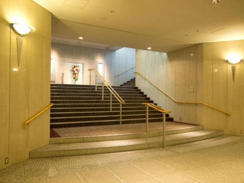 a hallway with stairs in a building with lights at Toshi Center Hotel in Tokyo