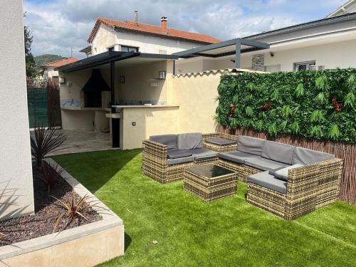 une cour arrière avec deux canapés sur l'herbe dans l'établissement La Détente, à Alès