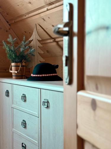 a hat sitting on top of a cabinet with a plant at Domki w Białce pod Basenami, 50 m od term i wyciągów in Białka Tatrzanska
