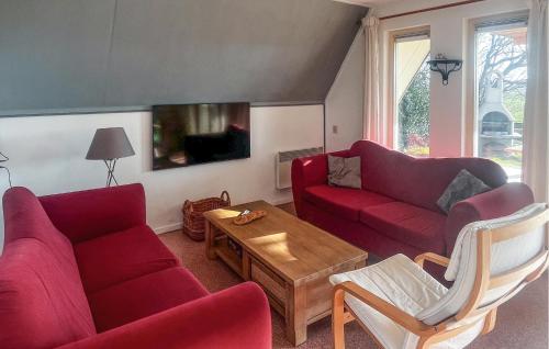 a living room with two red couches and a table at 3 Bedroom Nice Home In Den Oever in Den Oever