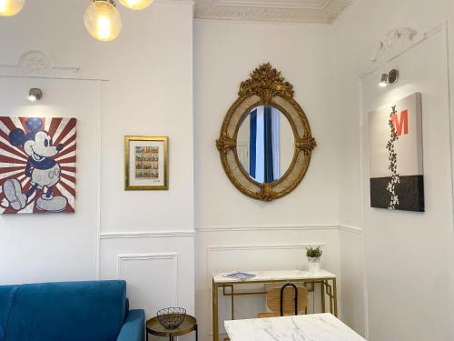 un salon avec un canapé bleu et un miroir dans l'établissement 72 - Mermoz Mickey Mouse, à Paris