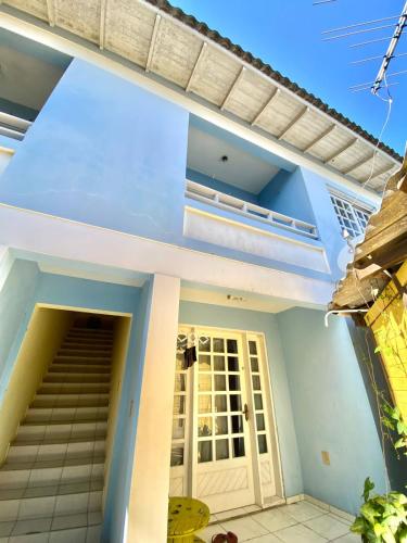 a house with blue walls and a white door at Pousada e Residencial Linda in Capão da Canoa